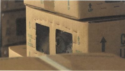 Stacked cardboard boxes with cutout windows in warehouse storage area