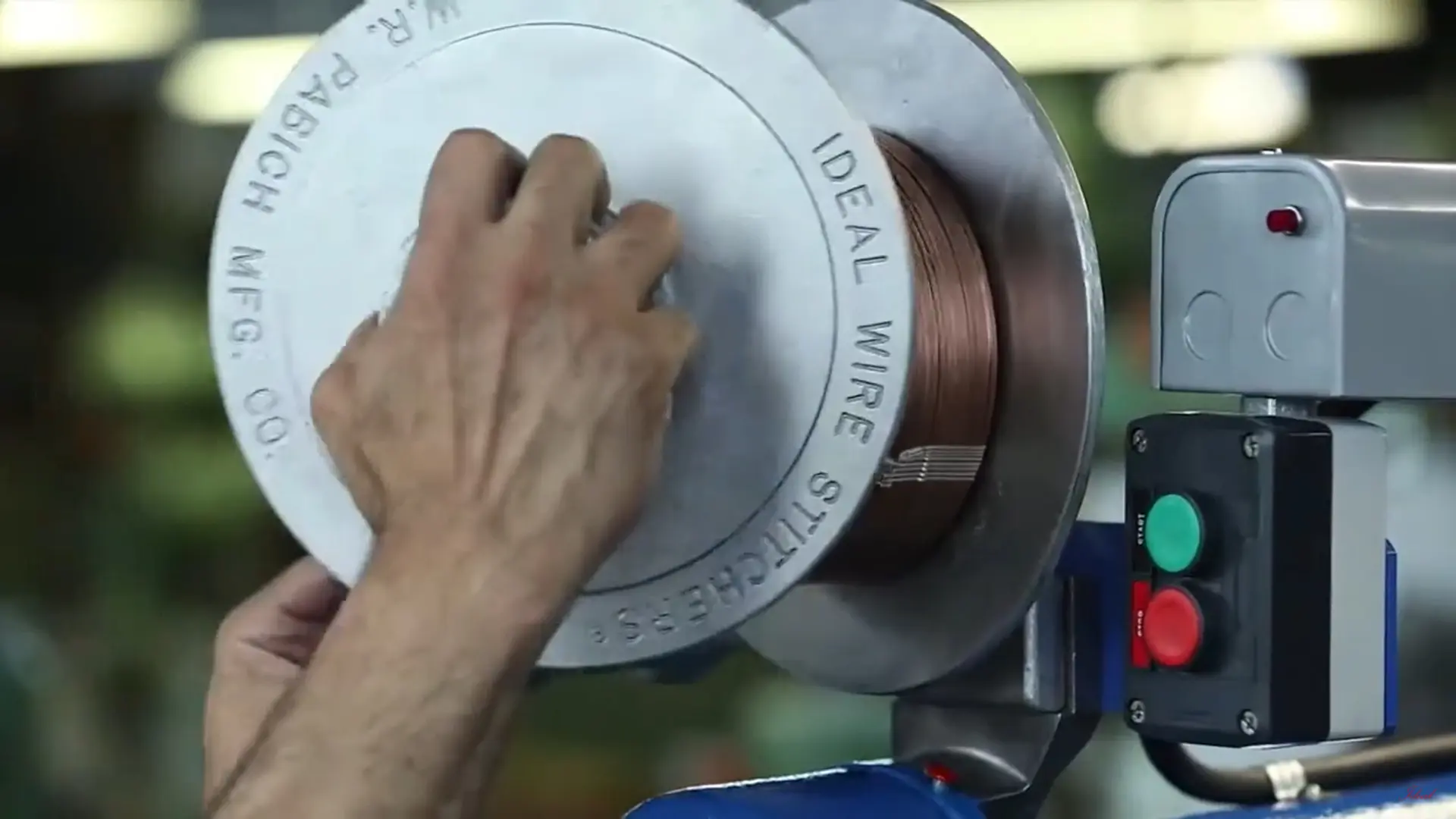 Hands operating a W.R. Pabich Mfg. Co. Ideal Wire stitcher spool.